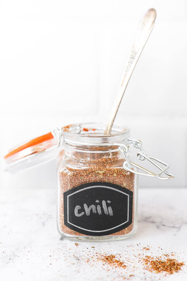 Chili seasoning in a jar with label with a spoon coming out top of jar