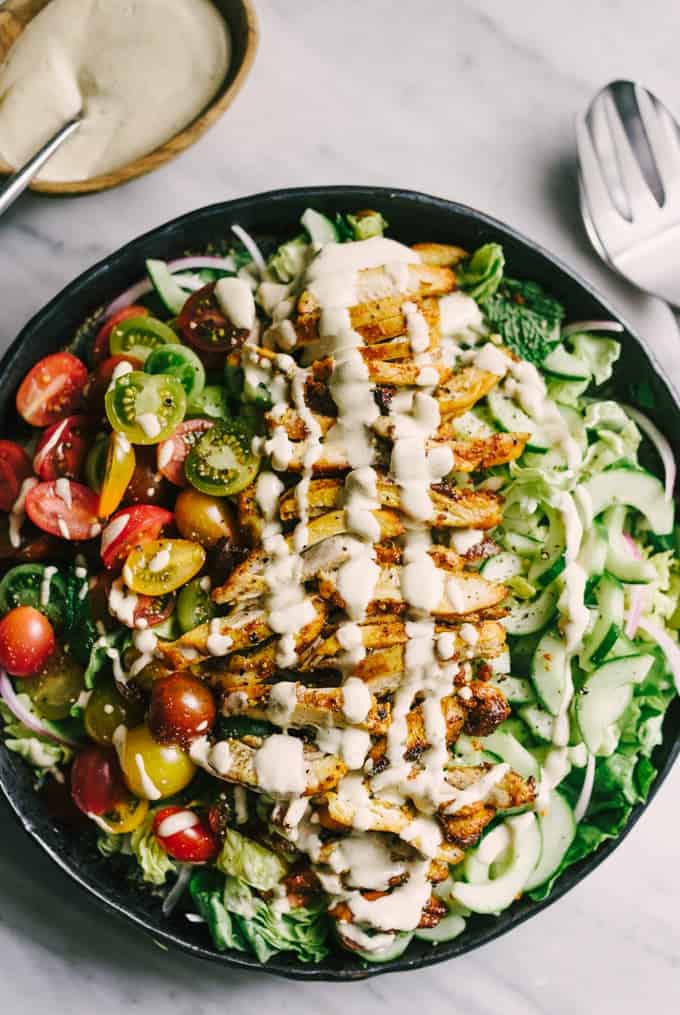 Chicken shawarma salad in bowl with dressing drizzle on top