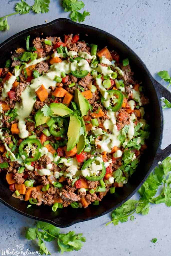 Beef and veggie taco skillet overhead shot with a swirl of sauce on top