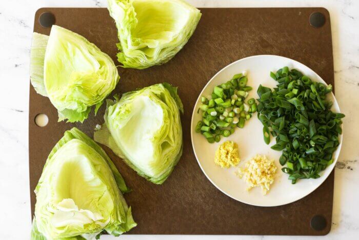 Overhead image of lettuce shells, chopped onions and grated ginger