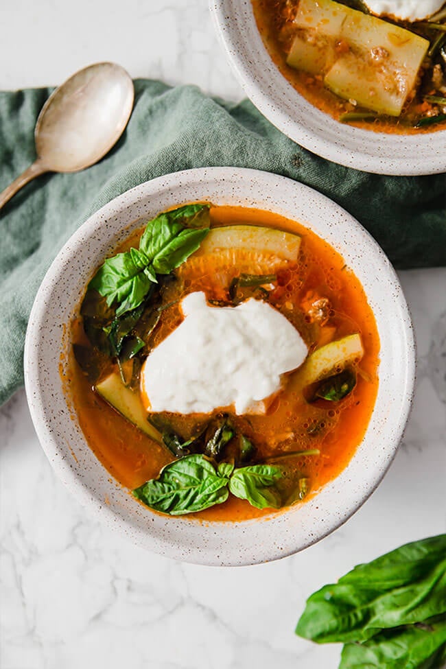 Paleo lasagna soup in a bowl with basil and cheese overhead shot