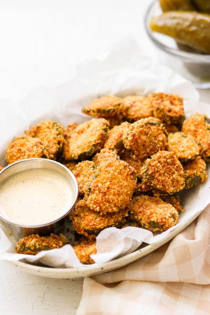 A plate of fried pickles with dipping sauce