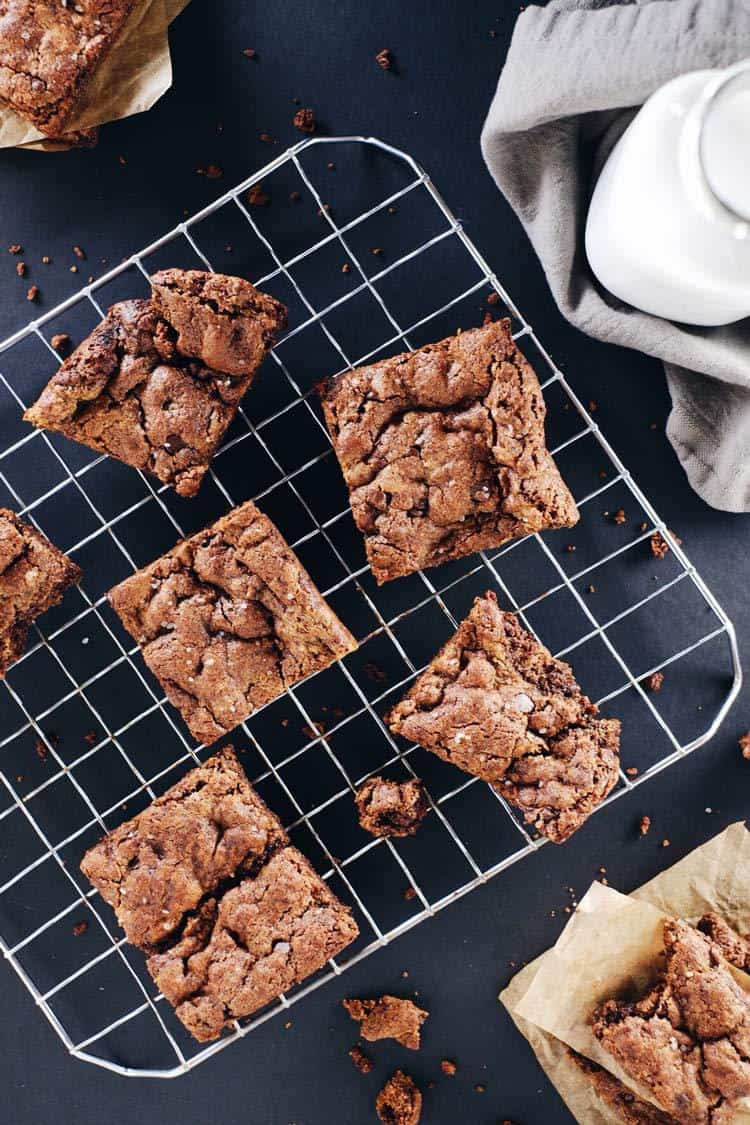 Fudge brownie pieces on a cooling rack with crumbs around