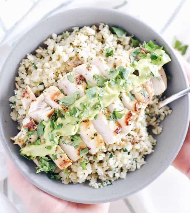 This cilantro lime chicken bowl is everything you need for a EASY Paleo + Whole 30 meal. Marinated chicken over cauliflower rice with a creamy avocado sauce! Paleo, Whole30, Gluten-Free and Dairy-Free. | realsimplegood.com