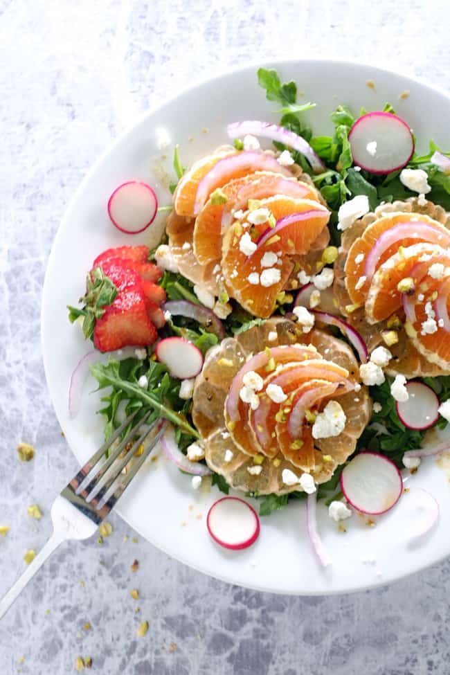 This summer citrus salad has layers of flavor from the spicy arugula, earthy radishes, sweet oranges and grapefruit to tangy goat cheese and pistachios. Paleo, Gluten-Free and Refined Sugar-Free. | realsimplegood.com