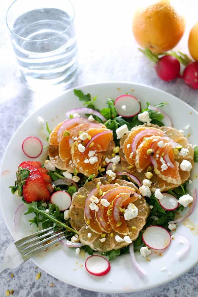 This summer citrus salad has layers of flavor from the spicy arugula, earthy radishes, sweet oranges and grapefruit to tangy goat cheese and pistachios. Paleo, Gluten-Free and Refined Sugar-Free. | realsimplegood.com