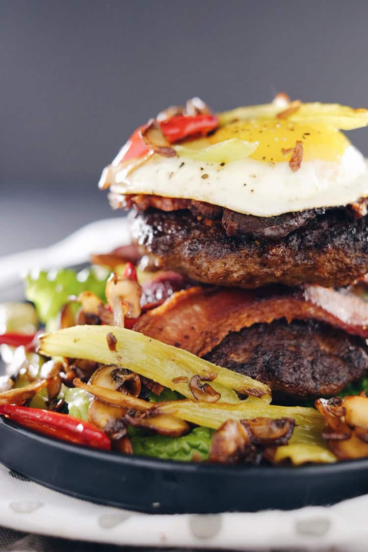 These chipotle bison burgers are an easy Paleo + Whole30 alternative to regular hamburgers. Topped with bacon, egg, peppers and mushrooms for amazing flavor! Paleo, Whole30, Gluten-Free + Dairy-Free | realsimplegood.com