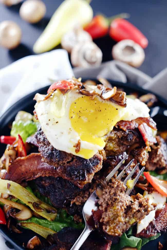 These chipotle bison burgers are an easy Paleo + Whole30 alternative to regular hamburgers. Topped with bacon, egg, peppers and mushrooms for amazing flavor! Paleo, Whole30, Gluten-Free + Dairy-Free | realsimplegood.com