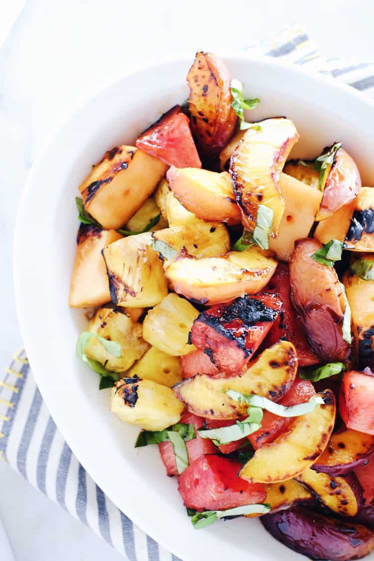 Have you tried grilling fruit yet? It is so delicious! Bring this Paleo + Whole30 grilled fruit salad to your next gathering to make you look like a pro! Grilled watermelon, peaches, cantaloupe and pineapple drizzled with balsamic and topped with basil. Paleo, Whole30, Gluten-Free + Refined Sugar-Free.| realsimplegood.com