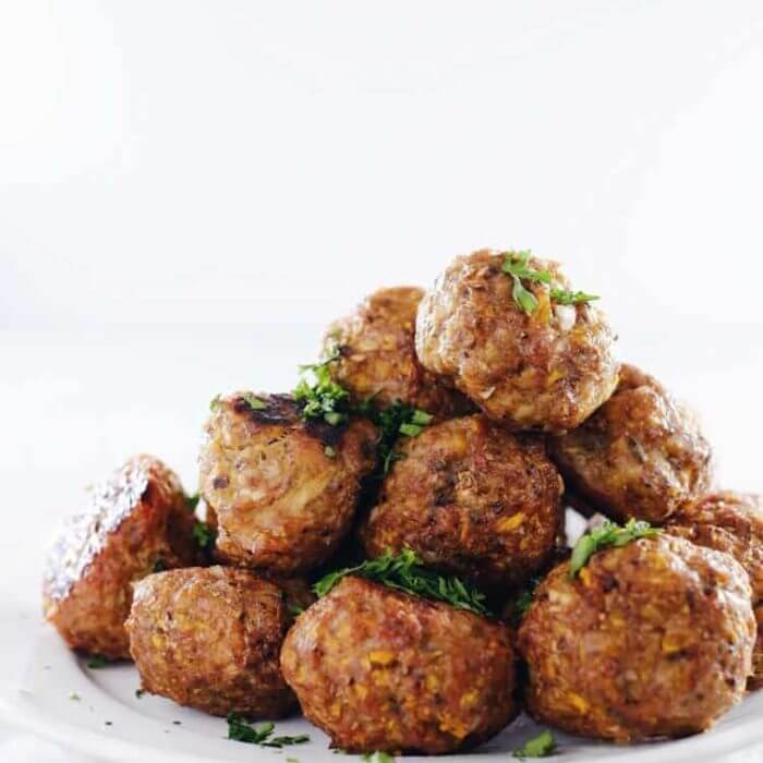 Stack of butternut breakfast meatballs on a white plate