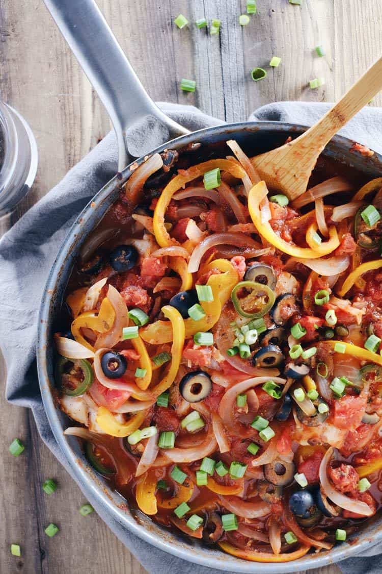 We love this veracruz style fish skillet because it is a refreshing Paleo + Whole30 way to enjoy fish! It's bursting with fresh veggies and flavors! Paleo, Whole30, Gluten-Free + Dairy-Free. | realsimplegood.com