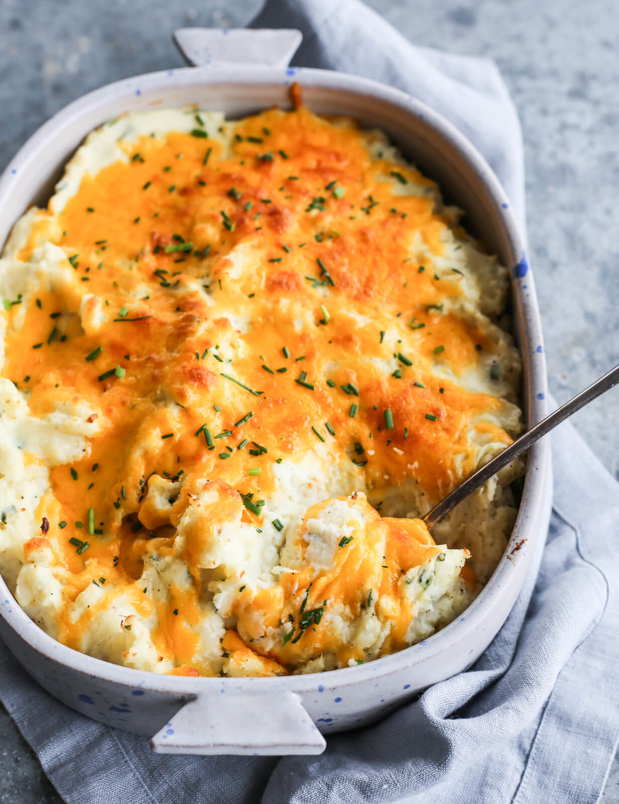 Angle image of cheesy potato casserole with chopped chive topping