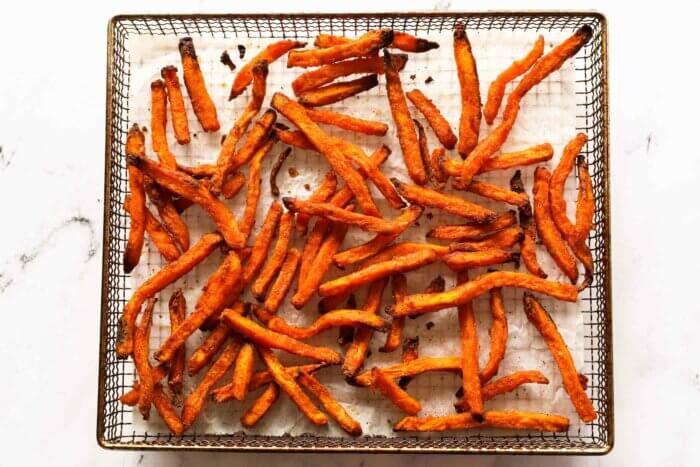 Cooked sweet potato fries in air fryer basket