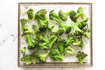 Cooked broccoli florets in air fryer basket