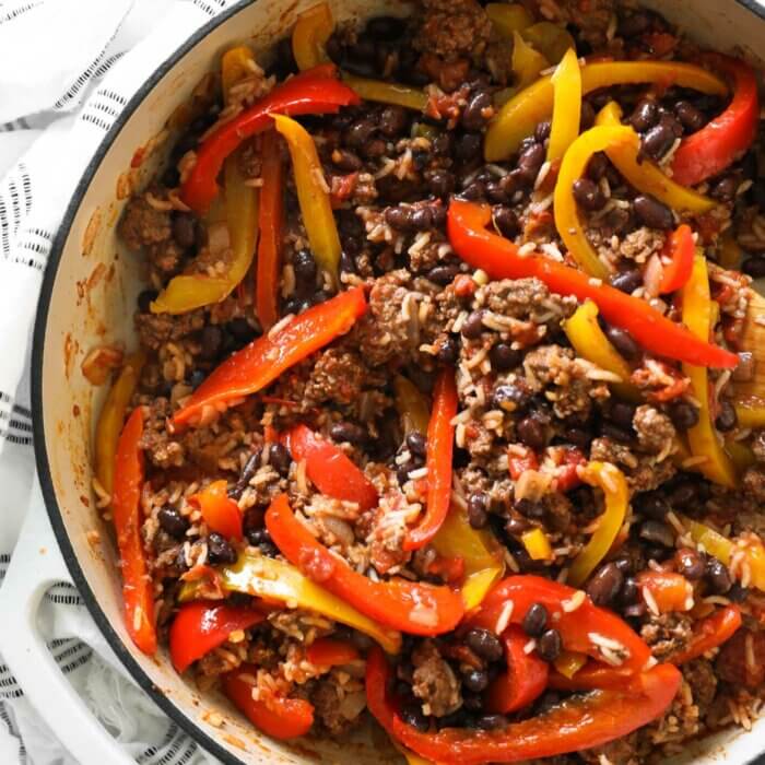 Close up overhead shot of deconstructed stuffed peppers in a pan with rice, beef and beans.