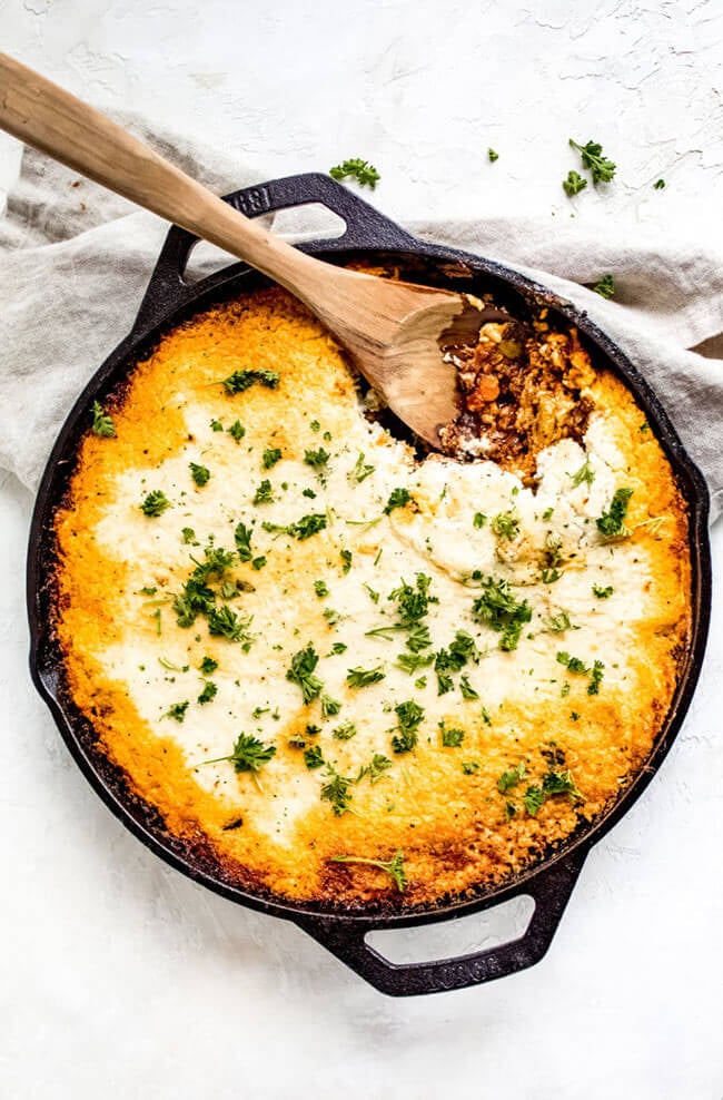 Keto Shepherd's pie in a cast iron skillet with scoop taken out and spoon in skillet