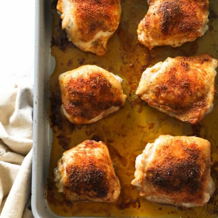 Overhead shot of a pan full of baked bone in chicken thighs