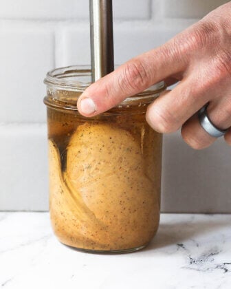 Close up image of sauce ingredients being emulsified in a mason jar.