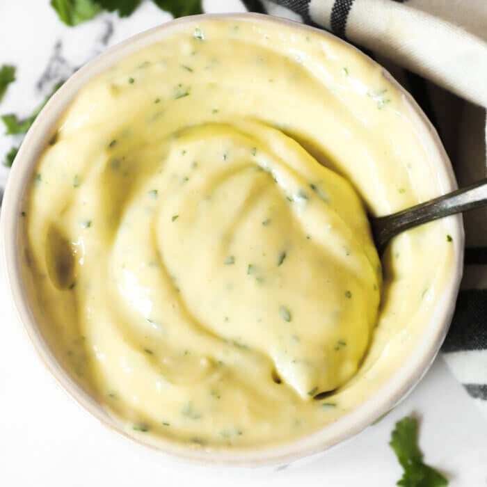 Overhead image of ramekin with cilantro lime aioli and spoon in it.