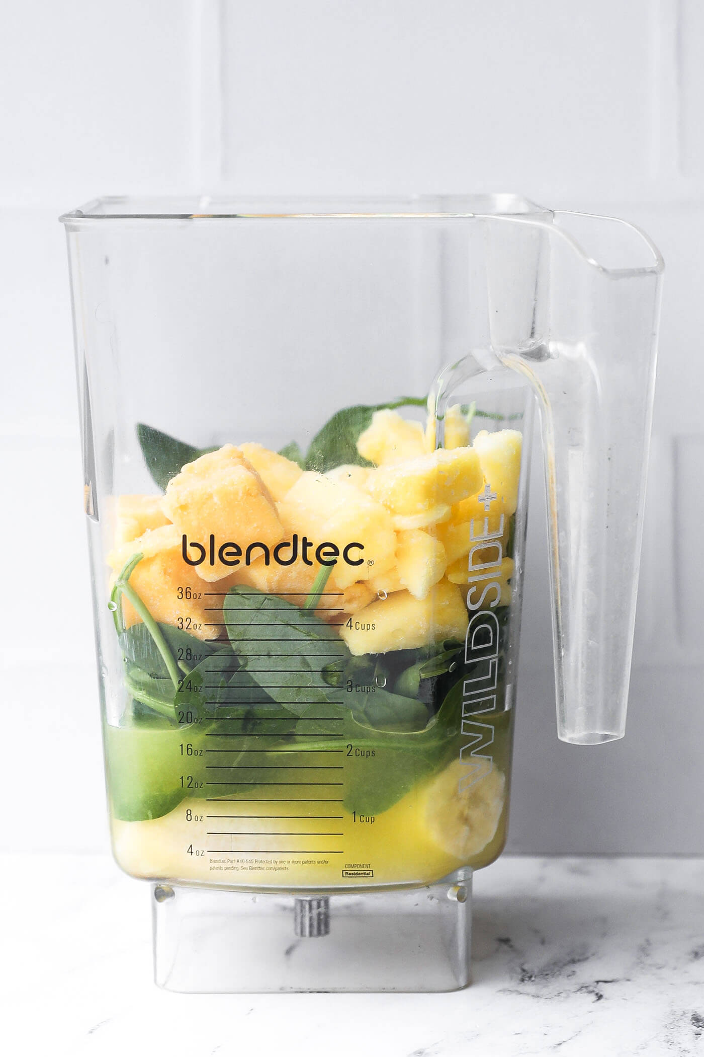 All of the smoothie ingredients layered in a blender jar before blending. 