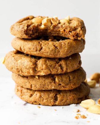 Image of a stack of five gluten free peanut butter cookies with the top cookie having a bite taken out of it.