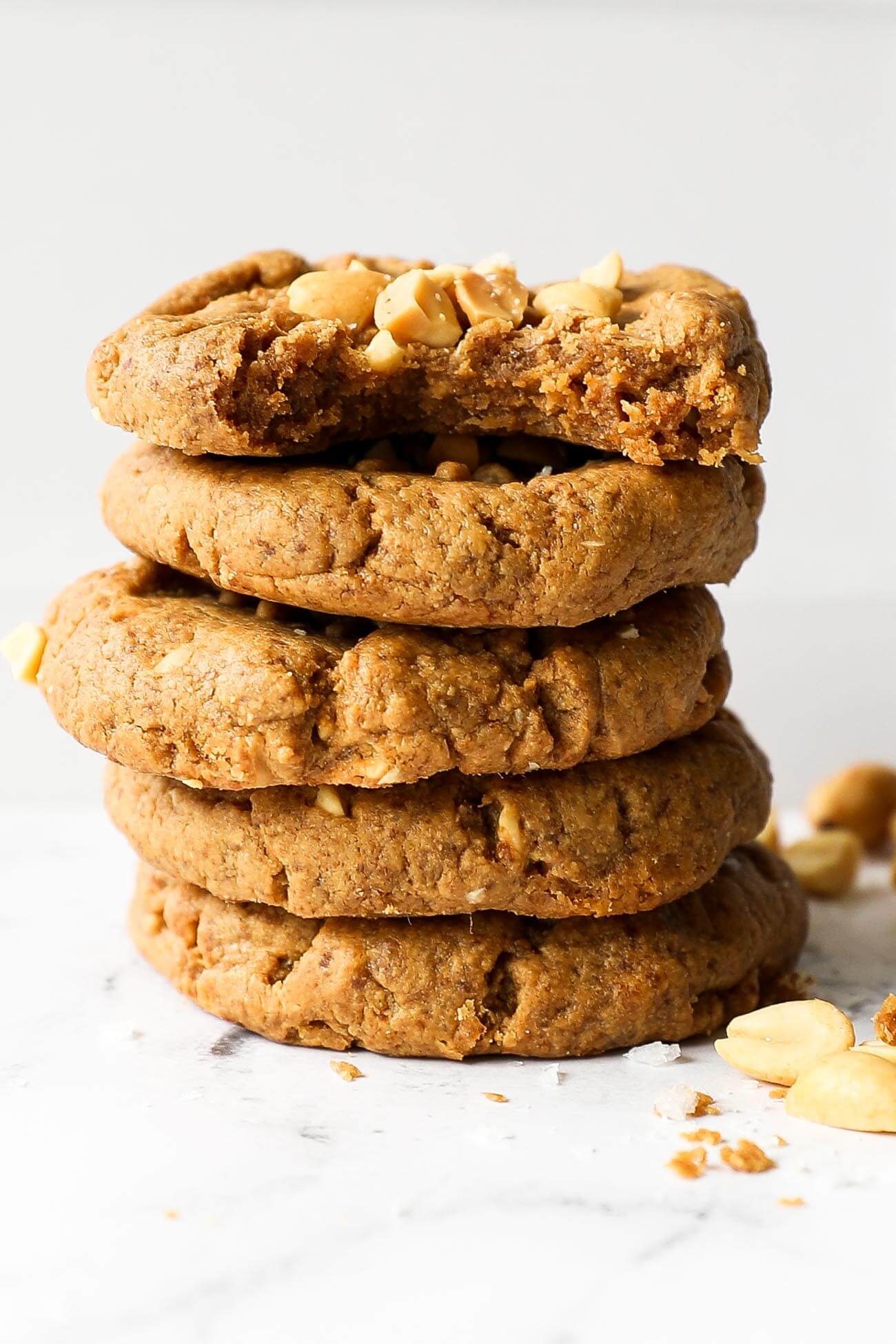 Image of a stack of five gluten free peanut butter cookies with the top cookie having a bite taken out of it.