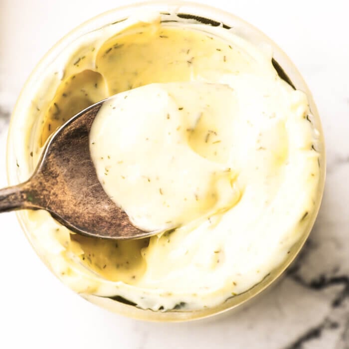 Overhead image of a spoonful of tartar sauce being lifted out of the jar.