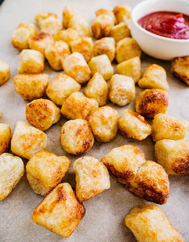 Cauliflower gnocchi nuggets on parchment paper with ketchup