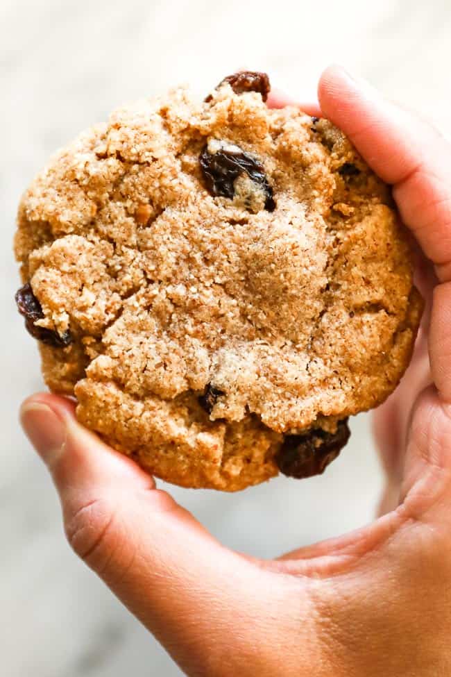 holding one almond butter cookie