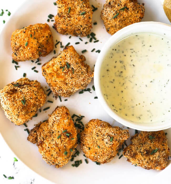 Gluten free air fryer chicken nuggets on a plate with ranch dipping sauce.