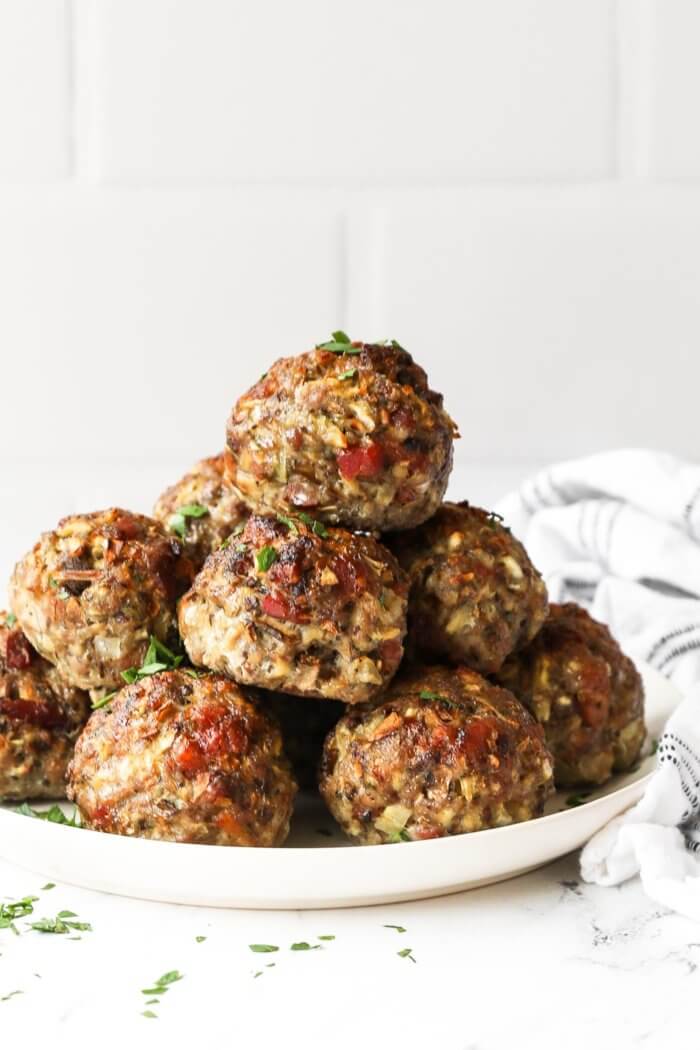 Breakfast sausage meatballs stacked up on a plate.
