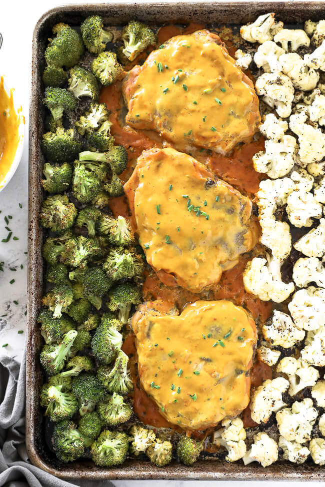 Honey mustard pork chops on a sheet pan with broccoli and cauliflower. 