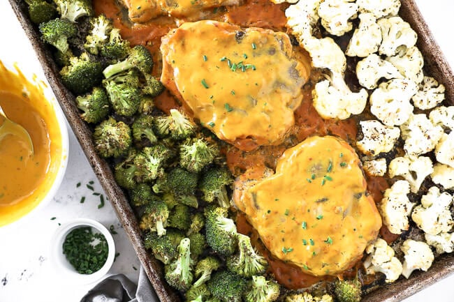 Honey mustard pork chops on a sheet pan with broccoli and cauliflower. 