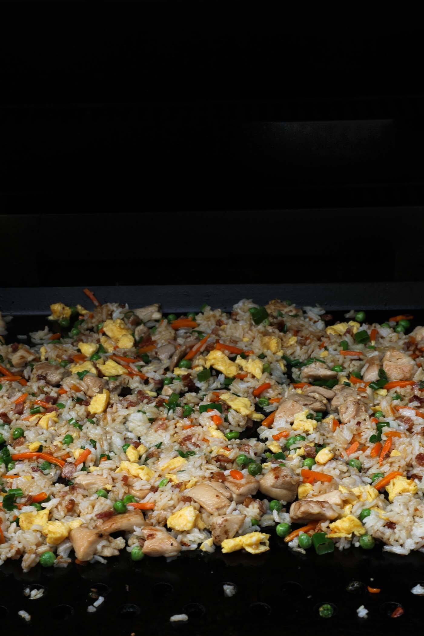 All of the fried rice ingredients cooked and spread out on the blacktop to get crispy bits formed.
