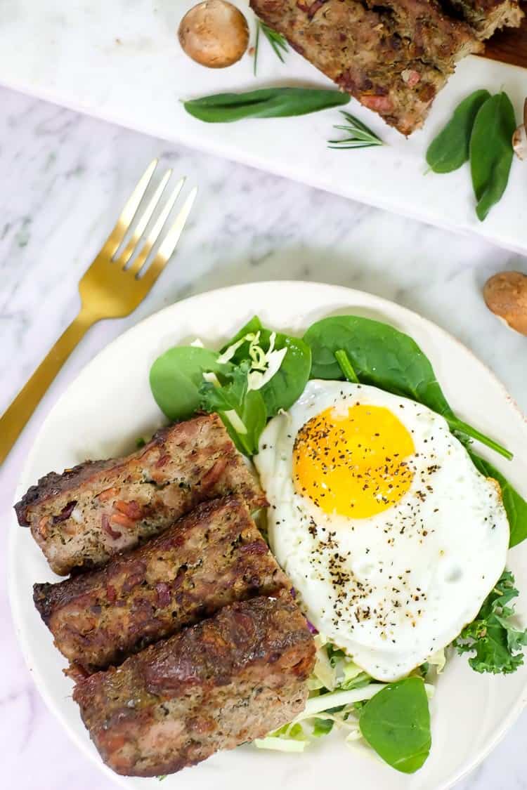 Breakfast meatloaf with bacon vertical overhead with egg and fork