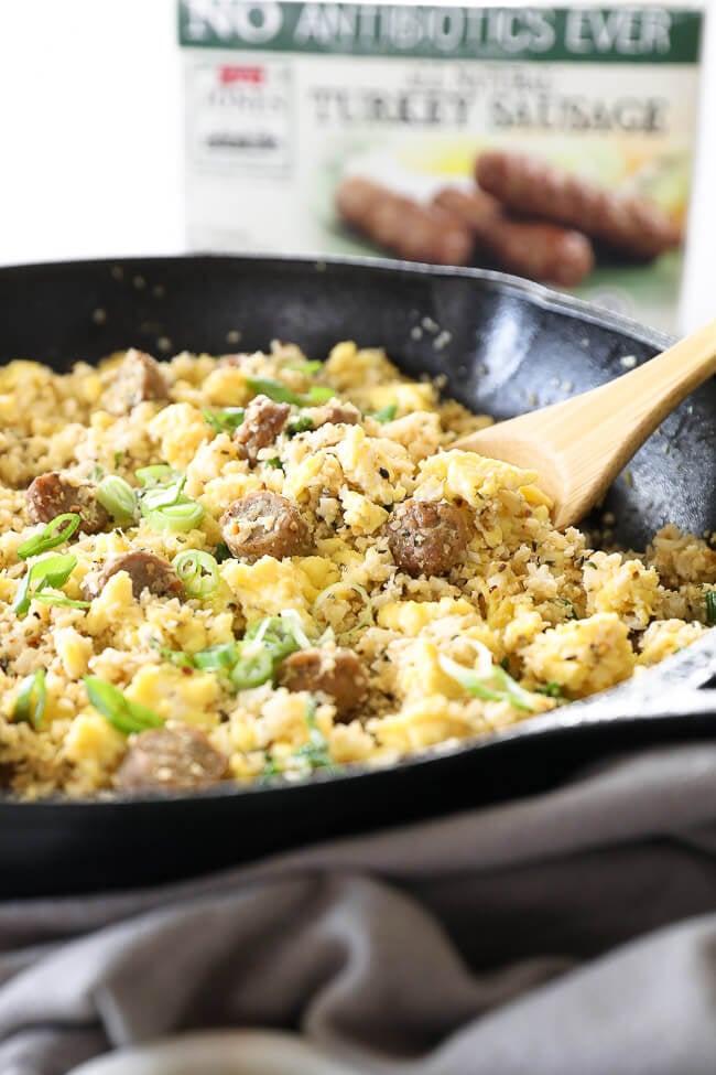 Angled image of breakfast fried rice in skillet with wooden spoon. 
