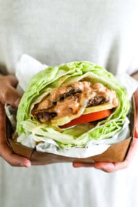 Bunless burger recipe vertical image hands holding burger