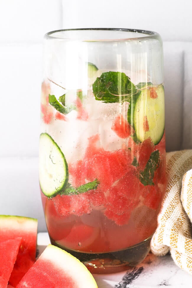 Close up of tall glass filled with watermelon cucumber mojito mocktail. 