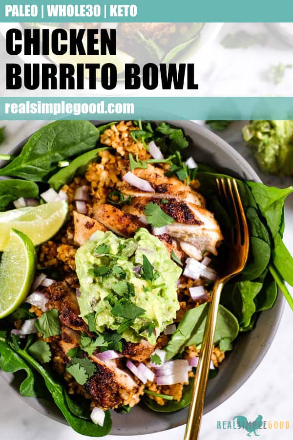 Close up of chicken burrito bowl, topped with chopped red onion, guacamole, cilantro and lime wedges in a bowl with a fork. Long pin for pinterest.