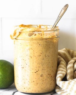 Straight on shot of a mason jar full of chipotle aioli with spoon sticking out