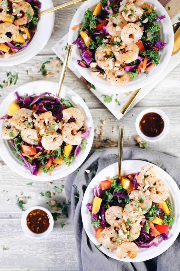 This chopped Thai shrimp salad is like eating the rainbow! It's packed with fruit, veggies and fresh herbs! Make this nutritious salad filled with kale, cabbage, bell pepper, carrots, mango and cilantro. It’s super easy and quick to make! Paleo, Whole30 + Gluten-Free, Dairy-Free. | realsimplegood.com