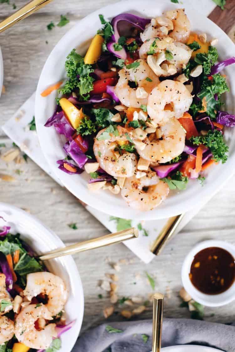 This chopped Thai shrimp salad is like eating the rainbow! It's packed with fruit, veggies and fresh herbs! Make this nutritious salad filled with kale, cabbage, bell pepper, carrots, mango and cilantro. It’s super easy and quick to make! Paleo, Whole30 + Gluten-Free, Dairy-Free. | realsimplegood.com