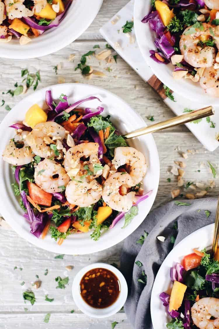 This chopped Thai shrimp salad is like eating the rainbow! It's packed with fruit, veggies and fresh herbs! Make this nutritious salad filled with kale, cabbage, bell pepper, carrots, mango and cilantro. It’s super easy and quick to make! Paleo, Whole30 + Gluten-Free, Dairy-Free. | realsimplegood.com