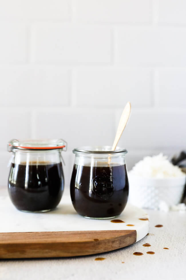 Homemade coconut aminos in two jars on a countertop with rice in background