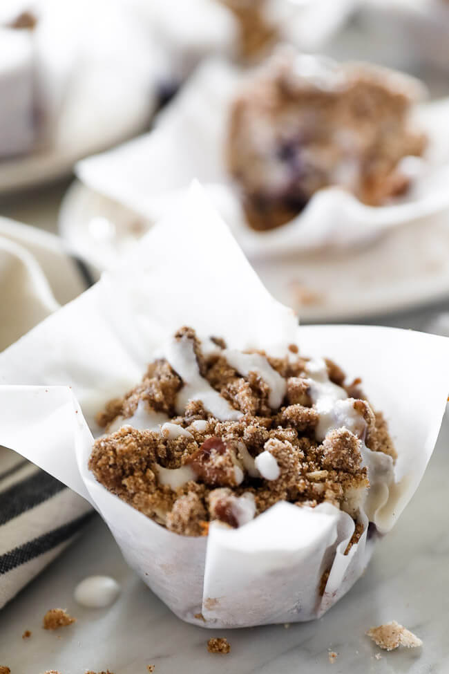 Close up vertical angled image of one coffee cake muffin with coconut butter drizzle on top. 