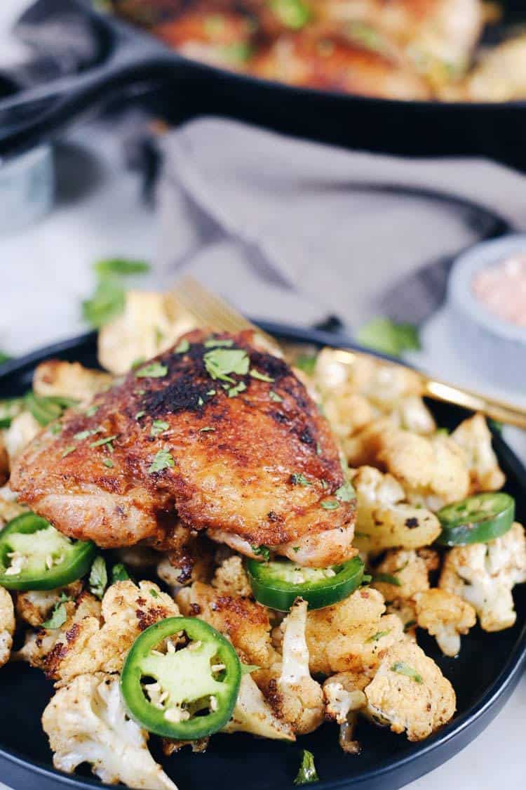 Crispy chicken thighs with zesty cauliflower are the perfect Paleo + Whole30 spicy meal. Packed with flavor, including citrus, cilantro and jalapeño! Paleo + Whole30. | realsimplegood.com