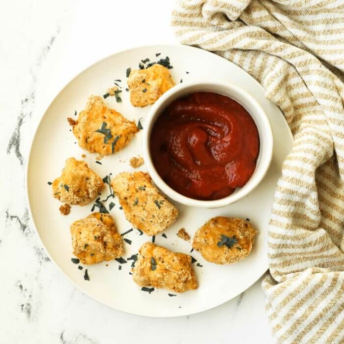 Overhead shot of keto chicken nuggets on a plate with ramekin of ketchup