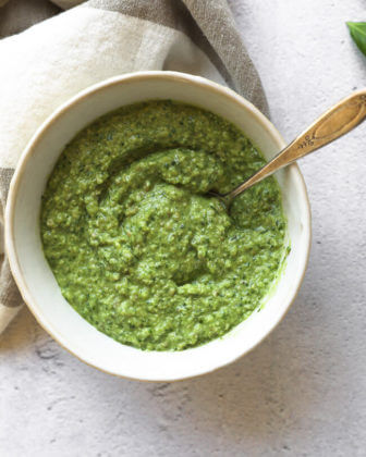 Overhead shot of nut free and dairy free pesto in a bowl with spoon in the bowl
