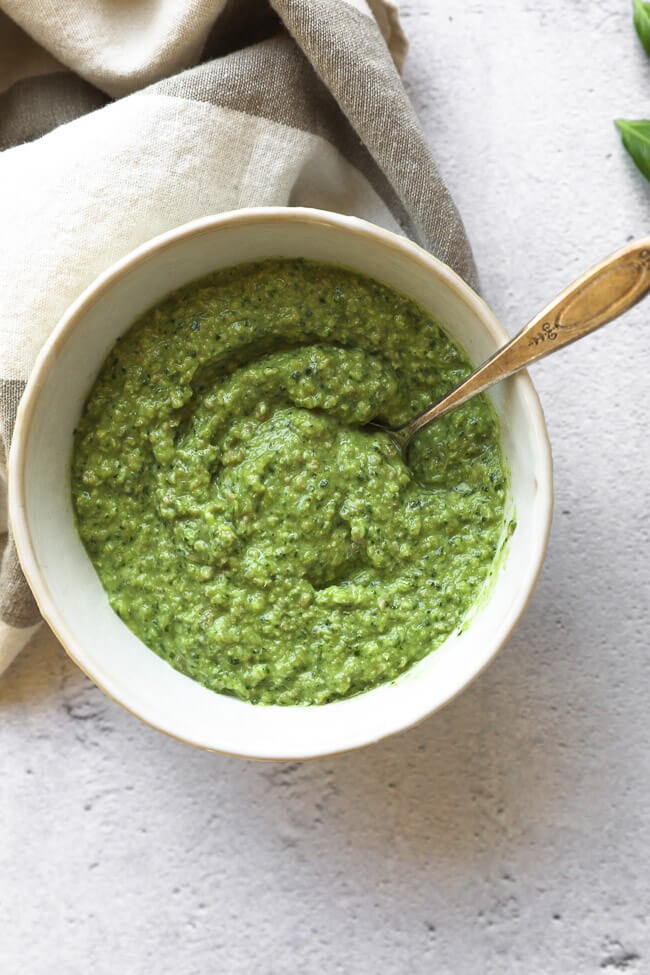 Bowl of dairy free and nut free pesto in a bowl with a spoon.