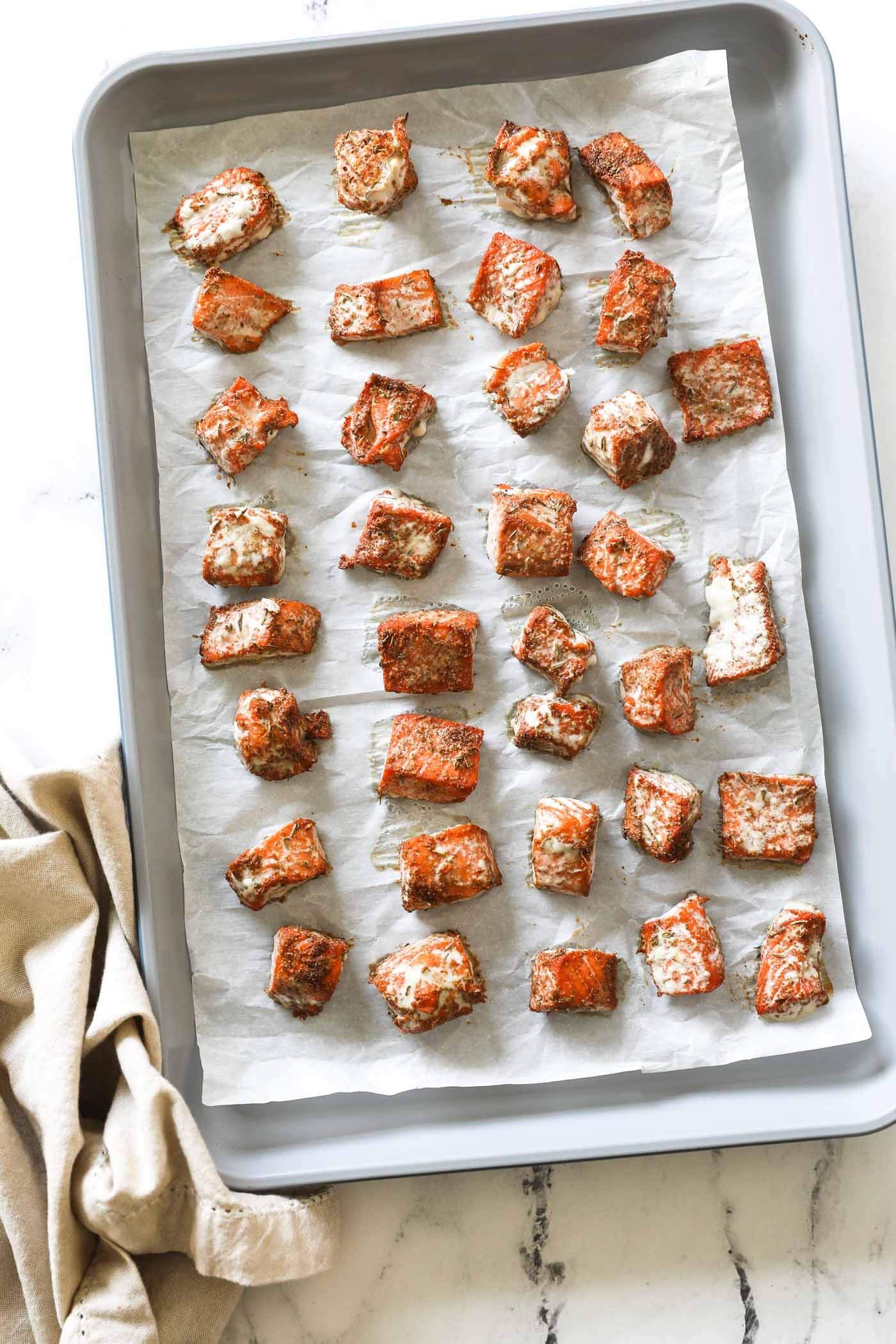 Cooked salmon bites on a baking sheet lined with parchment paper